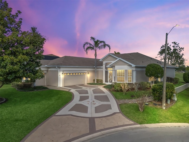 ranch-style house featuring a garage and a lawn