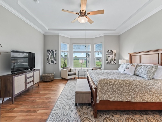 bedroom featuring hardwood / wood-style floors, crown molding, a raised ceiling, and ceiling fan