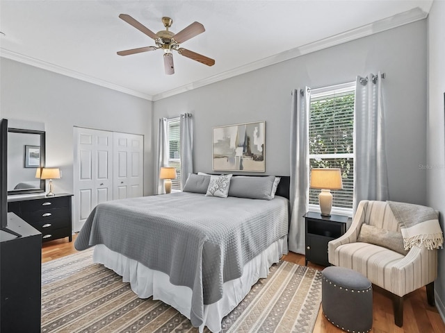 bedroom featuring crown molding, ceiling fan, hardwood / wood-style floors, and a closet