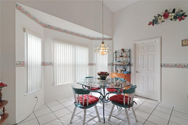 dining room with light tile patterned floors, an inviting chandelier, and high vaulted ceiling