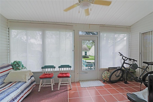sunroom / solarium with a ceiling fan and tile patterned flooring