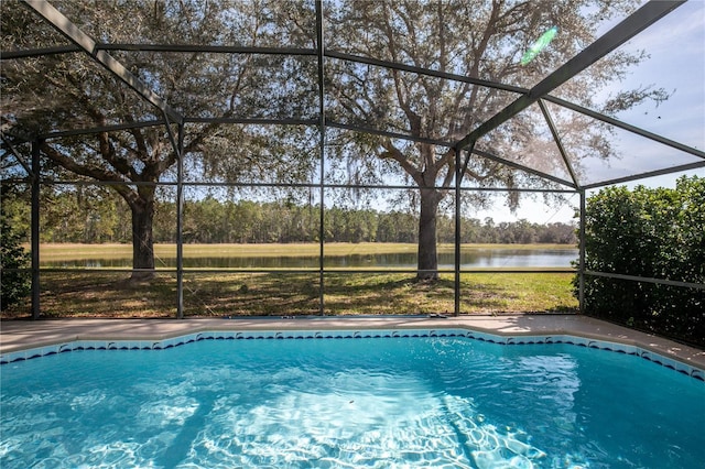 view of swimming pool with glass enclosure and a water view