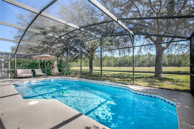 view of pool with a patio area and glass enclosure