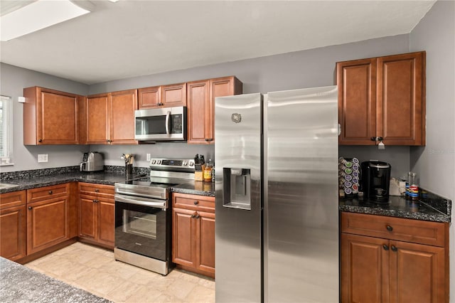 kitchen featuring stainless steel appliances and dark stone counters