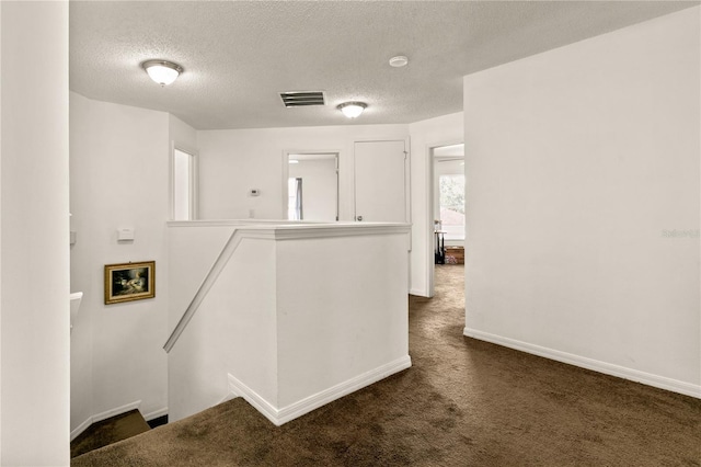 washroom with dark colored carpet and a textured ceiling