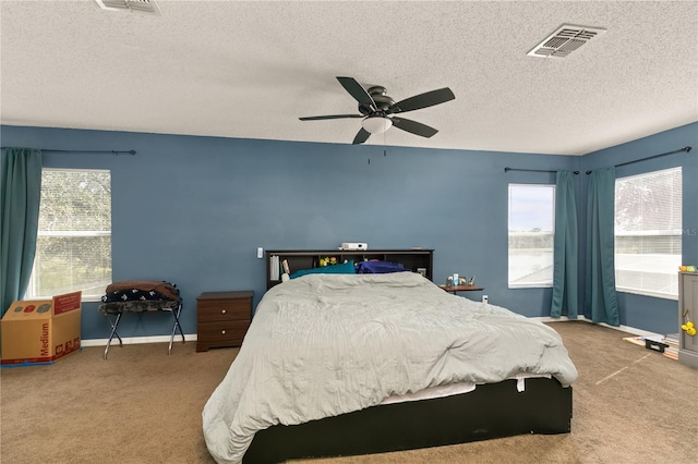 carpeted bedroom with a textured ceiling and ceiling fan