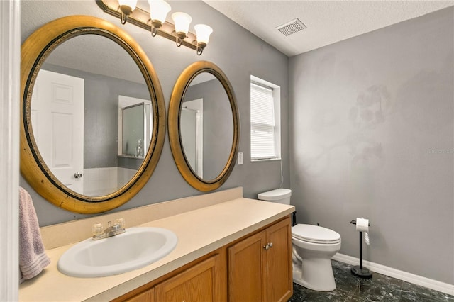 bathroom featuring vanity, toilet, and a textured ceiling