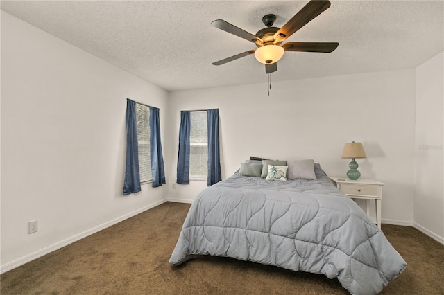 bedroom featuring ceiling fan, a textured ceiling, and dark colored carpet