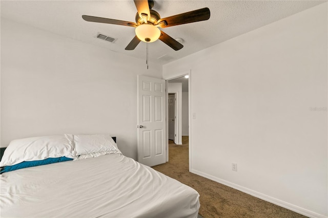 bedroom with dark colored carpet, a textured ceiling, and ceiling fan