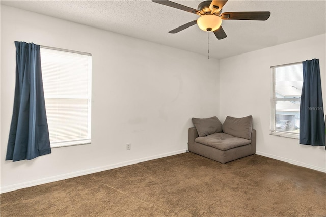 unfurnished room featuring ceiling fan, a textured ceiling, and dark colored carpet