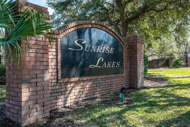 community / neighborhood sign featuring a yard