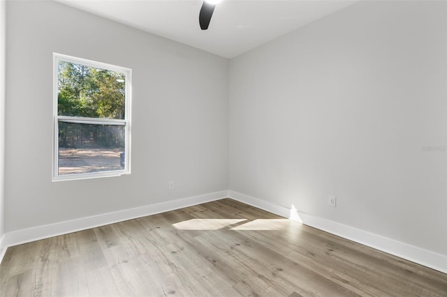 spare room featuring a ceiling fan, baseboards, and wood finished floors