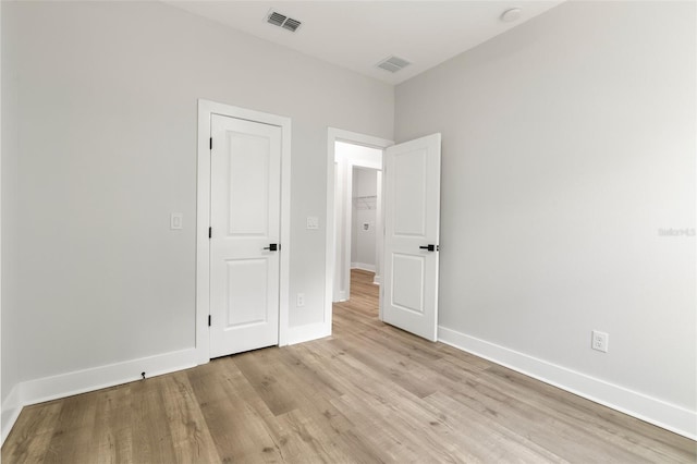 unfurnished bedroom featuring visible vents, light wood-style flooring, and baseboards