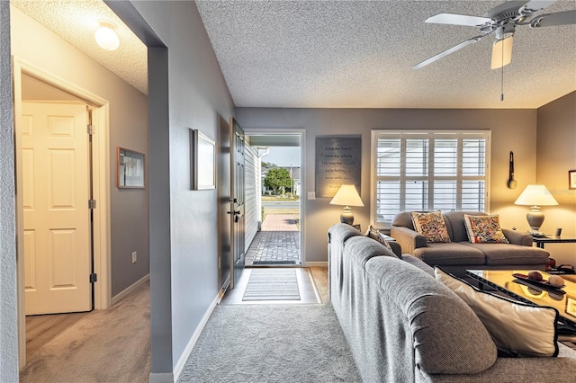 carpeted living room with ceiling fan and a textured ceiling