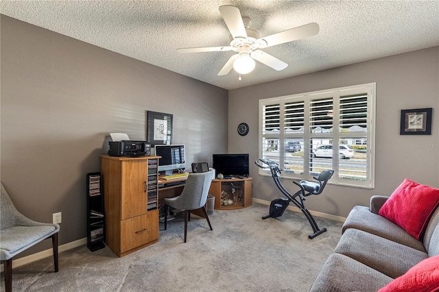 home office with a textured ceiling, light colored carpet, and ceiling fan