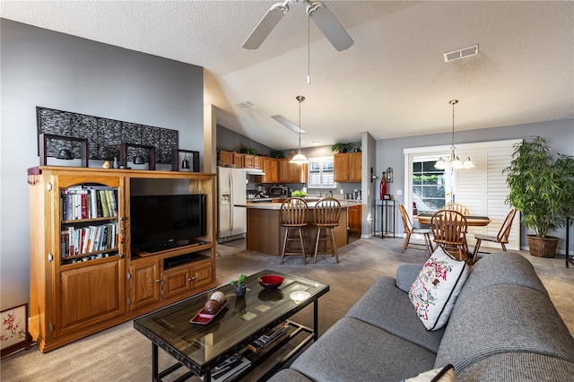 carpeted living room with lofted ceiling, ceiling fan with notable chandelier, and a textured ceiling