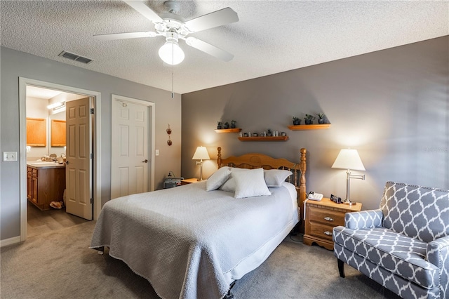 bedroom with sink, ceiling fan, ensuite bathroom, a textured ceiling, and light carpet