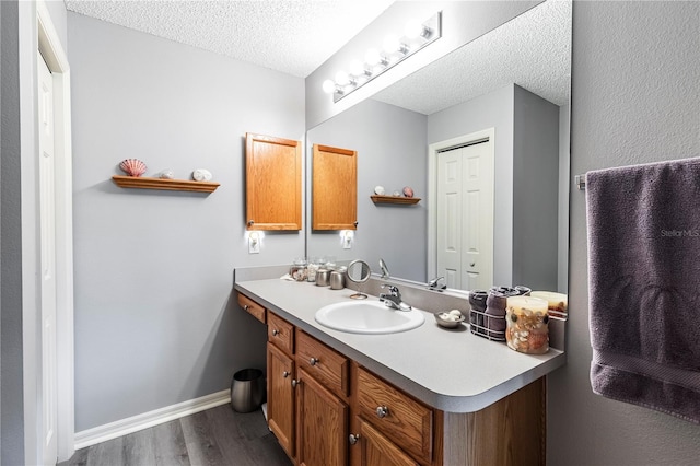 bathroom with vanity, hardwood / wood-style floors, and a textured ceiling