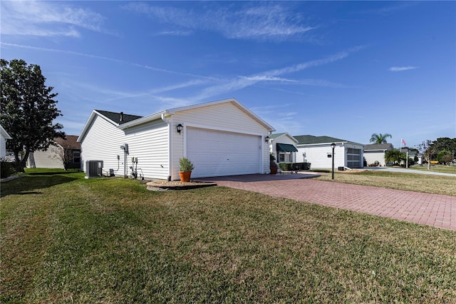 view of side of property with a garage, central air condition unit, and a lawn