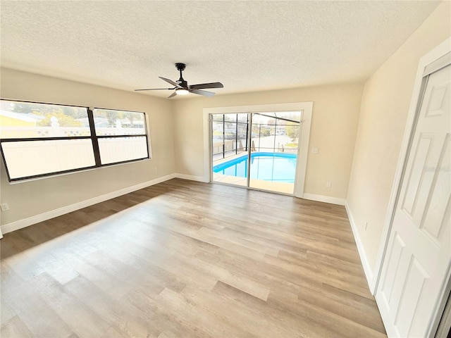 unfurnished room with ceiling fan, a textured ceiling, and light hardwood / wood-style flooring