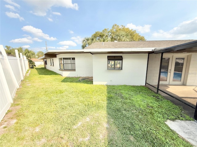 rear view of property featuring a lawn