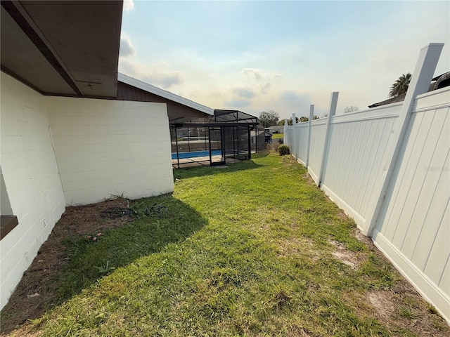 view of yard with a swimming pool and glass enclosure