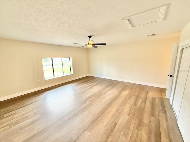 spare room featuring light hardwood / wood-style floors and a textured ceiling