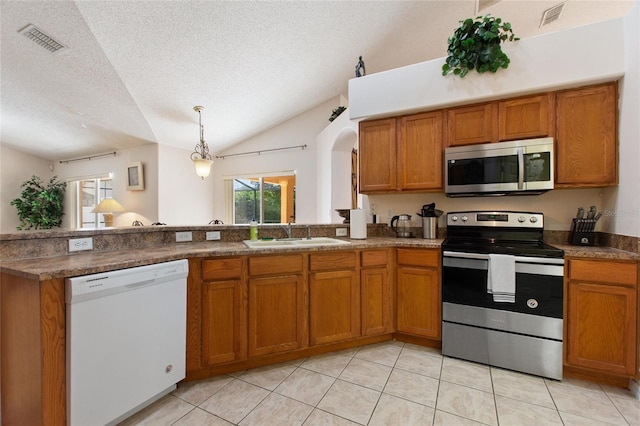 kitchen featuring sink, vaulted ceiling, a textured ceiling, and appliances with stainless steel finishes