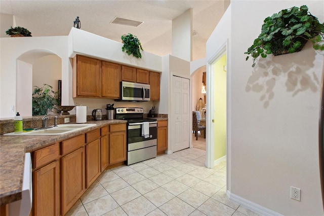 kitchen with stainless steel appliances, light tile patterned flooring, and sink