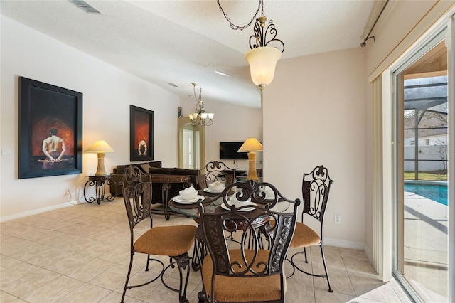 tiled dining room with plenty of natural light, an inviting chandelier, lofted ceiling, and a textured ceiling