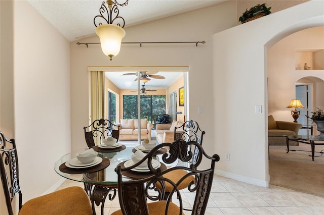 tiled dining area featuring ceiling fan, vaulted ceiling, and a textured ceiling