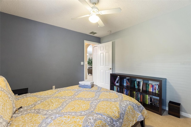 bedroom featuring ceiling fan, carpet flooring, and a textured ceiling