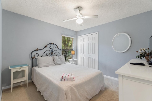 bedroom with light colored carpet, a textured ceiling, and a closet