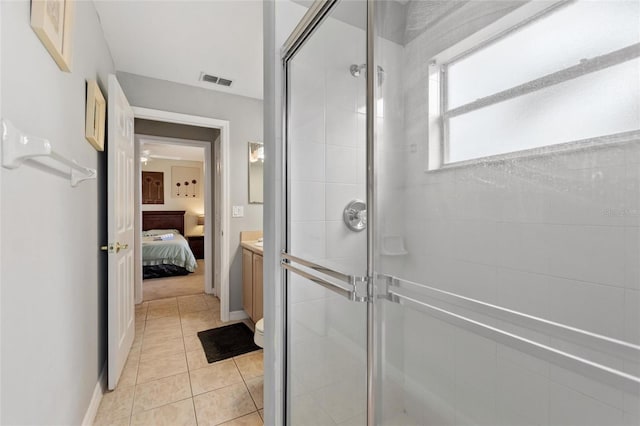 bathroom with tile patterned flooring, a shower with shower door, and toilet