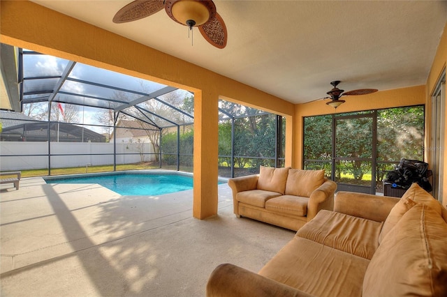 view of swimming pool with a patio, outdoor lounge area, ceiling fan, and glass enclosure