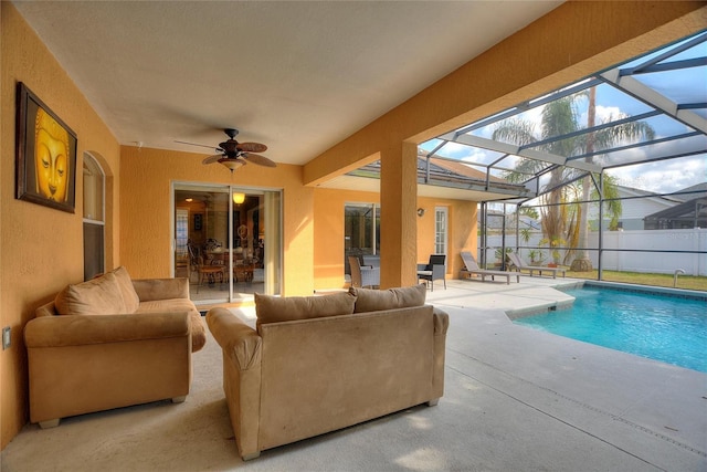 view of pool with a lanai, outdoor lounge area, ceiling fan, and a patio area