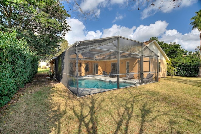 view of swimming pool featuring a yard, a patio area, and glass enclosure