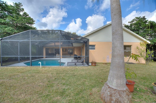 view of swimming pool featuring a patio, glass enclosure, and a lawn