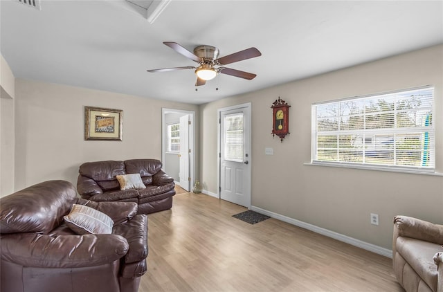 living room with ceiling fan, a wealth of natural light, and light wood-type flooring