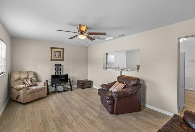 living room with ceiling fan and light hardwood / wood-style flooring