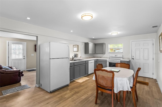 kitchen featuring light hardwood / wood-style flooring, sink, white appliances, and gray cabinets