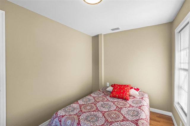 bedroom featuring multiple windows and wood-type flooring