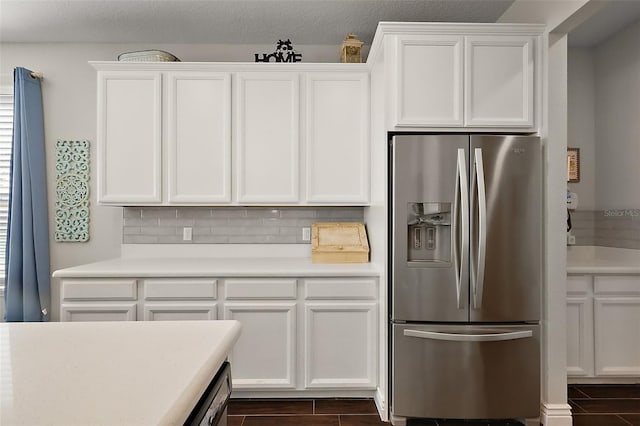 kitchen featuring stainless steel refrigerator with ice dispenser, backsplash, and white cabinets