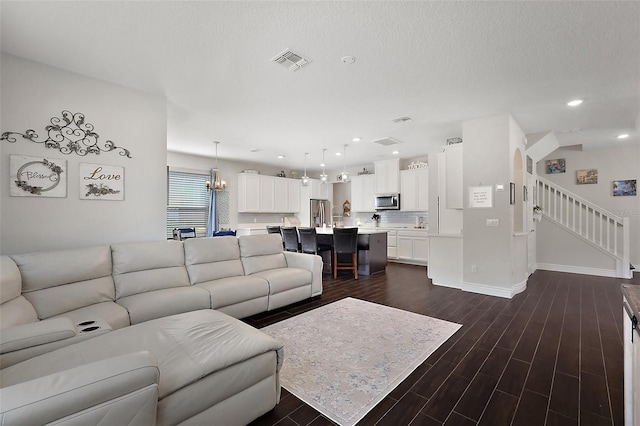 living room featuring a textured ceiling and dark hardwood / wood-style flooring