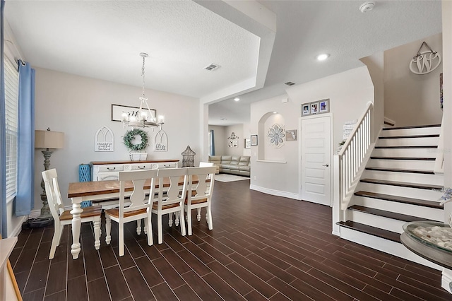 dining space featuring a textured ceiling and an inviting chandelier