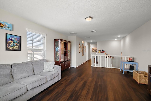 living room with dark hardwood / wood-style floors and a textured ceiling