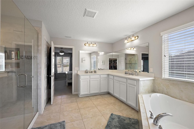 bathroom featuring tile patterned flooring, vanity, plus walk in shower, and a textured ceiling