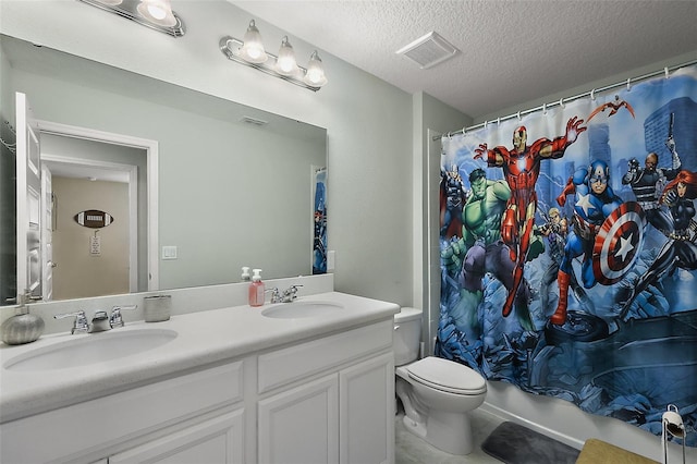 bathroom with vanity, toilet, and a textured ceiling