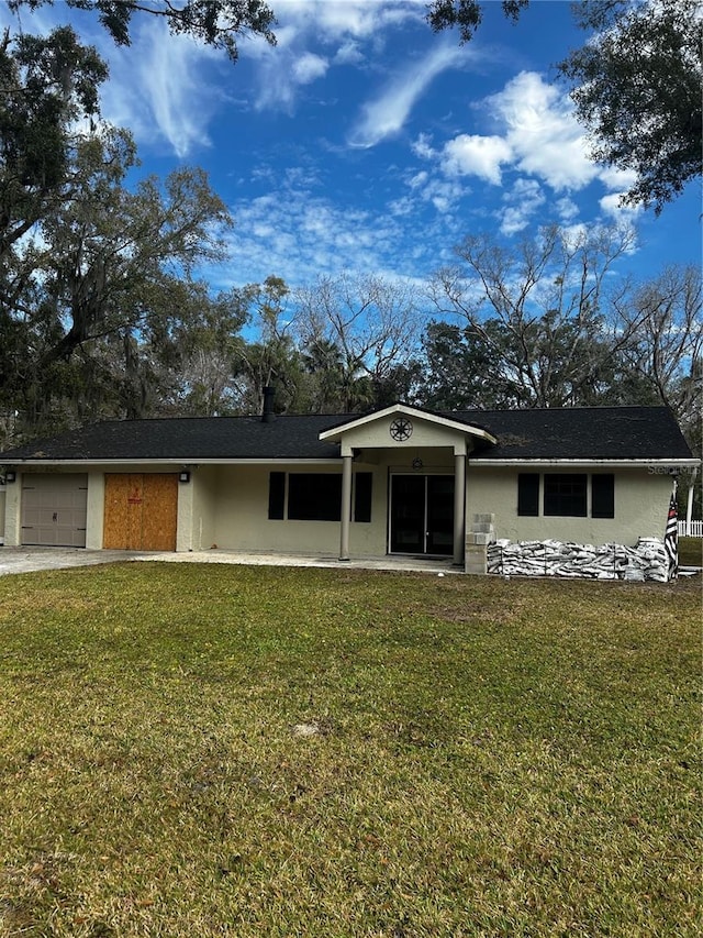 ranch-style home featuring a garage and a front lawn