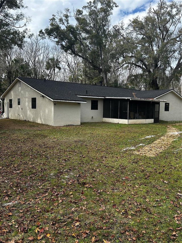 back of house featuring a yard and a sunroom